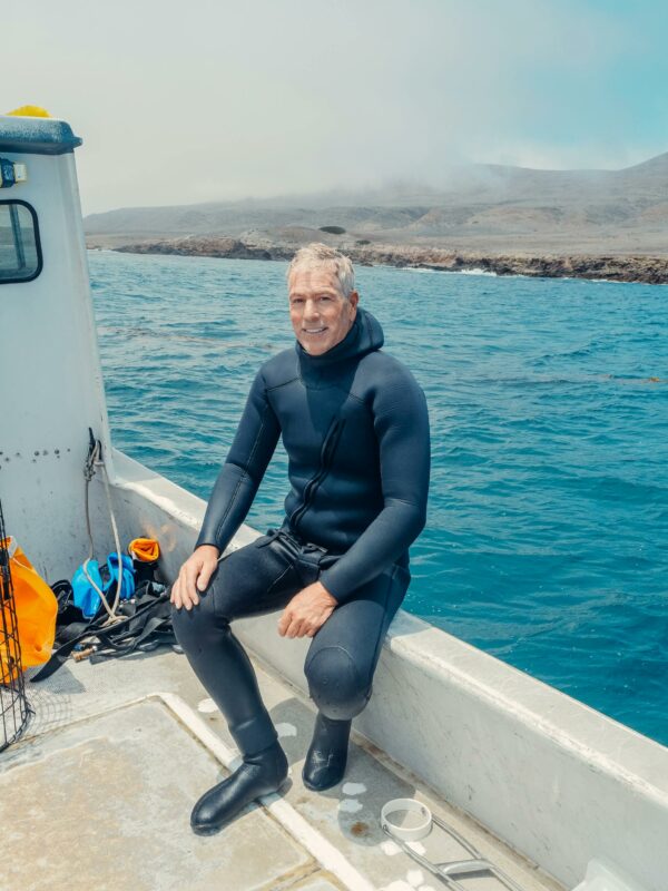 A Man in a Boat Wearing a Scuba Diving Suit