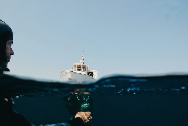 A Yacht On Sea And Man Underwater